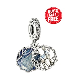 May include: A silver charm with a winter forest scene and a deer in a circular frame. The charm has a sparkling, crystal-studded band and is marked with the brand name and silver content.