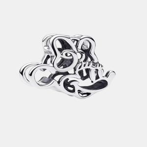 May include: A silver charm with the word "Sister" in a cursive font. The charm is made of a shiny metal and has a detailed design. The word "Pandora" is engraved on the side of the charm.