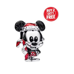 May include: A silver Mickey Mouse charm wearing a Santa hat and holding a candy cane. The charm features black ears with white speckles and a red and white candy cane. A red circle with the text "BUY 2 GET 1 FREE" is also visible.