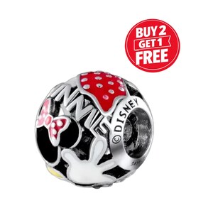 May include: A silver charm bead with a Minnie Mouse design. The bead features a red polka dot pattern, a pink bow, and the word "DISNEY" engraved on the side. A red circle with the text "BUY 2 GET 1 FREE" is in the background.