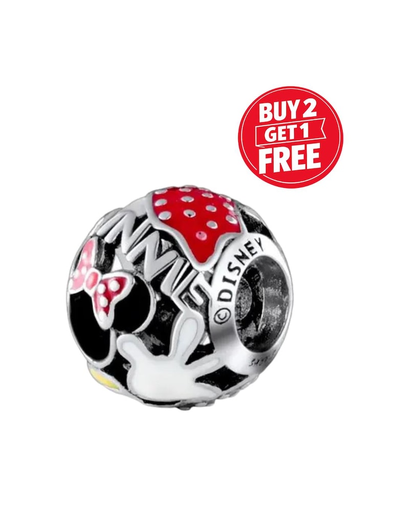 May include: A silver charm bead with a Minnie Mouse design. The bead features a red polka dot pattern, a pink bow, and the word "DISNEY" engraved on the side. A red circle with the text "BUY 2 GET 1 FREE" is in the background.