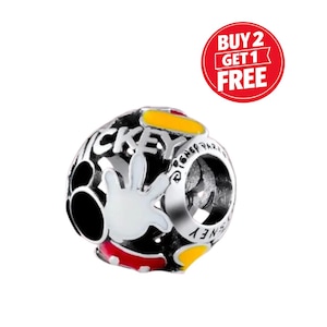 Puede incluir: Un charm plateado con el tema de Mickey Mouse. El charm presenta un dise&ntilde;o en blanco y negro con la mano de Mickey, la palabra "Mickey" y detalles en amarillo y rojo. El charm tiene forma redonda y se puede leer el texto "Disney Park".