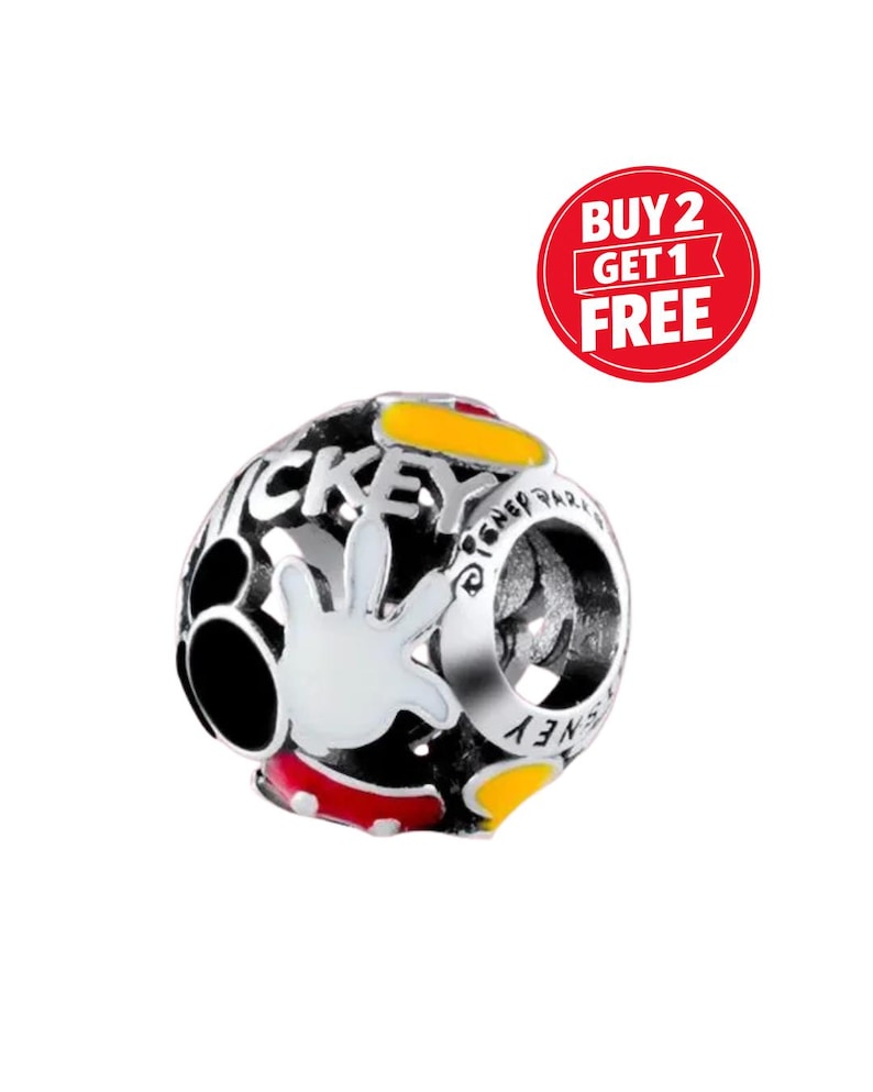 Puede incluir: Un charm plateado con el tema de Mickey Mouse. El charm presenta un dise&ntilde;o en blanco y negro con la mano de Mickey, la palabra "Mickey" y detalles en amarillo y rojo. El charm tiene forma redonda y se puede leer el texto "Disney Park".