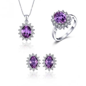 May include: A jewelry set consisting of a necklace with an oval purple gemstone pendant, a matching ring with an oval purple gemstone, and two stud earrings, each featuring an oval purple gemstone surrounded by a halo of small clear stones.