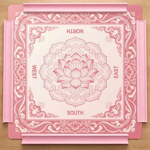 May include: A square pink game board featuring a central lotus flower illustration surrounded by intricate floral and cloud patterns. The board includes four raised pink side rails and the directional labels North, South, East, and West printed in pink.