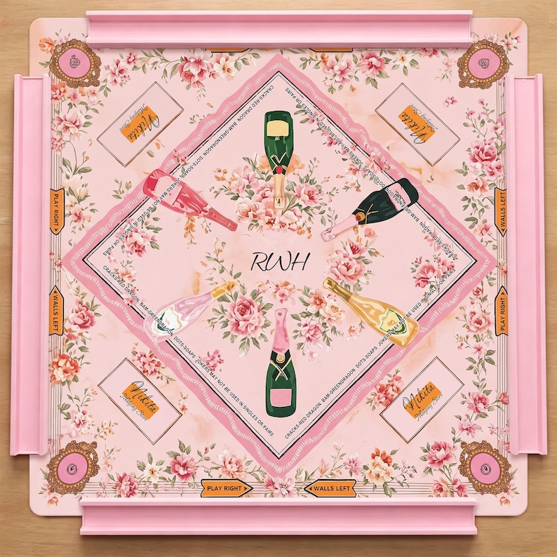 May include: A square board game with a light pink floral background featuring four champagne bottles in green, pink, and gold. The center displays the letters RWH. Four corners contain ornate frames, and the edges feature pink racks and text.