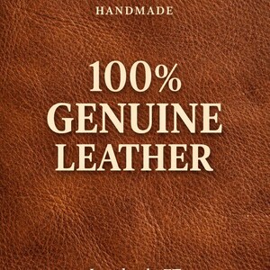 Peut inclure: Gros plan sur du cuir marron avec le texte "HANDMADE" en haut, "100% GENUINE LEATHER" au centre et "LeatherbyZT" en bas. Le cuir pr&eacute;sente une surface textur&eacute;e.