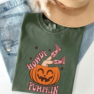 Maglietta "Howdy Pumpkin", maglietta western di Halloween, maglietta da cowgirl con zucca, stivali da cowboy rosa per Halloween, maglietta grafica autunnale, maglietta per la stagione spettrale