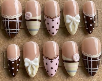 Unghie finte fatte a mano con decoro al cioccolato, fiocco, perla, manicure coquette