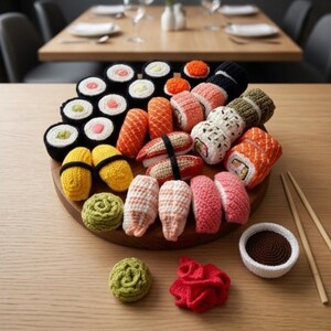 Könnte beinhalten: Eine Sammlung gehäkelter Sushi-Stücke, die auf einem runden Holzbrett angeordnet sind, darunter verschiedene Maki-Rollen, Nigiri und Sashimi. Das Set besteht aus strukturiertem Garn in Farben wie Weiß, Schwarz, Orange, Pink, Gelb und Grün, ergänzt durch eine kleine Schale mit Sojasauce und Holzstäbchen.