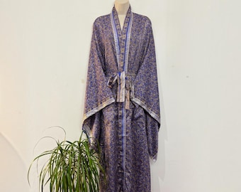 May include: A long-sleeved robe in a deep purple hue featuring an intricate gold floral pattern throughout. The garment includes a matching fabric tie belt at the waist and a contrasting vertical border design along the front opening and cuffs.