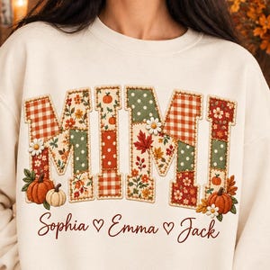 May include: A cream-colored crewneck sweatshirt featuring the word MIMI in large block letters with a patchwork pattern of orange, green, and white autumn motifs including pumpkins, leaves, and flowers. Below, the names Sophia, Emma, and Jack are printed.