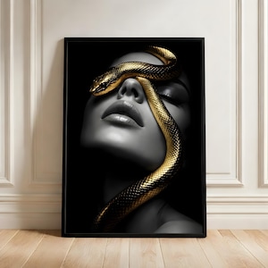 May include: A monochrome portrait of a woman with a golden snake coiled around her face. The snake's scales are intricately detailed, contrasting with the woman's pale skin. The artwork is presented within a black frame.