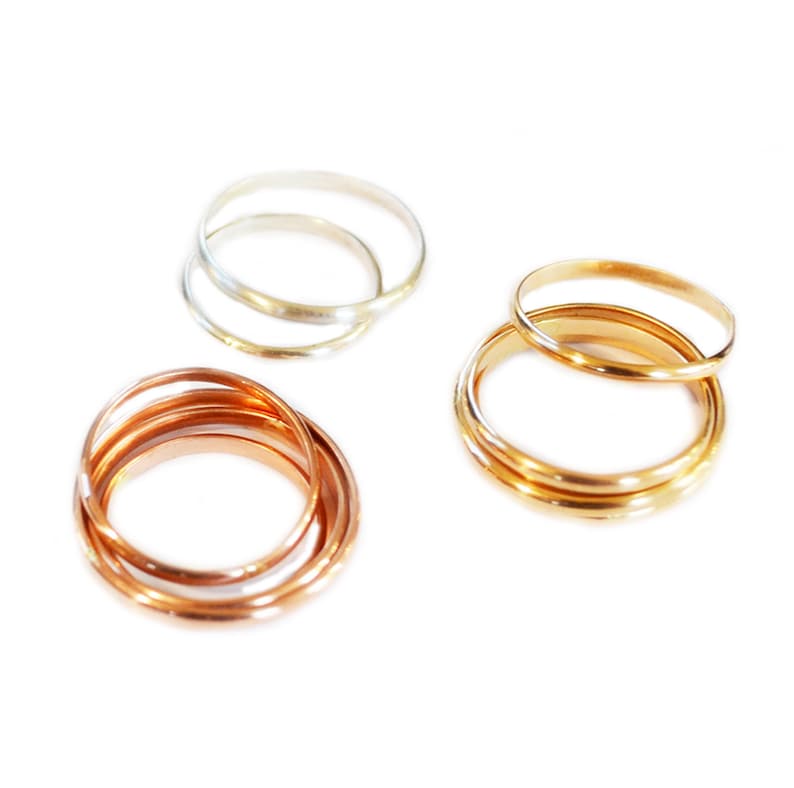 May include: Three sets of stacking rings in silver, gold, and rose gold. Each set has three rings of varying widths.