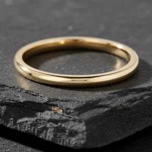 Könnte beinhalten: Eine weiße Keramik-Tasse mit schwarzem Henkel und dem Text "But First, Coffee" in schwarzer, fetter Schrift. Die Tasse steht auf einer weißen Oberfläche. Die Tasse ist etwa 10 cm hoch.