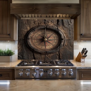 Puede incluir: Un protector contra salpicaduras de cocina con un diseño detallado de brújula sobre un fondo de madera envejecida. La brújula tiene una estética vintage con tonos rojos, marrones y dorados. El diseño está enmarcado por un borde ovalado oscuro.