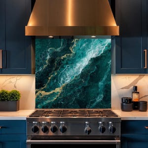 May include: A kitchen splashback panel featuring a deep teal and emerald green marble pattern with swirling white veins and metallic gold accents. The rectangular panel is positioned behind a stainless steel gas stove and under a copper range hood.