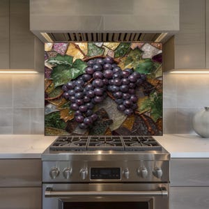May include: A decorative kitchen backsplash featuring a mosaic design of purple grapes and green leaves. The grapes are clustered on a brown vine, set against a backdrop of colorful, irregular glass pieces. The backsplash is mounted above a stainless steel gas range.