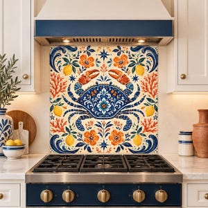 May include: A square decorative backsplash panel featuring a central blue crab with intricate floral and scroll patterns. The design includes orange flowers, yellow lemons, and coral-like branches on a cream background, positioned above a stove.