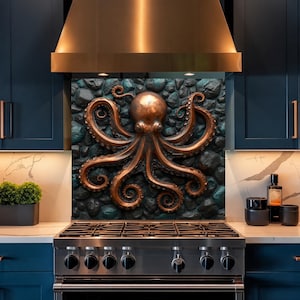 May include: A decorative wall panel featuring a three-dimensional copper-colored octopus sculpture centered against a dark, textured stone-like background. The octopus has eight curled tentacles and is positioned above a stainless steel kitchen stove.