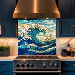 Könnte beinhalten: Eine quadratische Küchenrückwand mit einem Buntglas-Design, das eine große, brechende Meereswelle in Blau-, Türkis- und Cremetönen zeigt, wobei dunkle Bleilinien die einzelnen glasartigen Segmente voneinander abgrenzen.