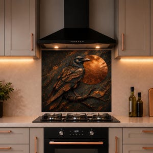 May include: A square kitchen backsplash panel featuring a dark, textured background with a large, detailed raven perched on a branch. A prominent, glowing copper-colored circular moon sits behind the bird, creating a high-contrast metallic aesthetic.