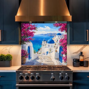 Puede incluir: Un panel de salpicadero de cocina que muestra una vibrante escena mediterránea con edificios blancos, cúpulas azules y flores de buganvilla de color rosa brillante con vistas a un mar azul profundo bajo un cielo despejado.