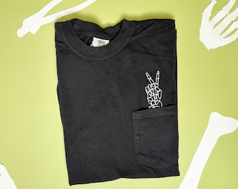 Unisex gesticktes Skeleton Peace Hand Pocket Tee - Komfortfarben