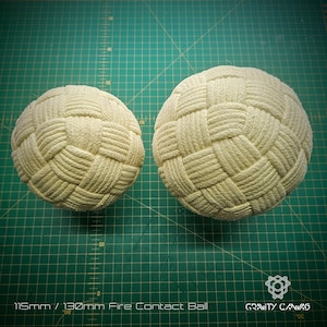 May include: Two cream-colored fire contact balls with a woven rope design. The balls are spherical and rest on a green cutting mat. The text at the bottom reads "115mm / 130mm Fire Contact Ball" and "GRAVITY CANVAS".