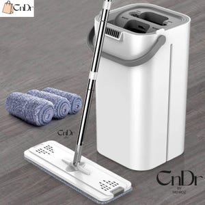 Puede incluir: Una taza de cerámica blanca con asa negra y el texto "But First, Coffee" en negrita negra. La taza se encuentra sobre un fondo borroso, sugiriendo un ambiente acogedor.