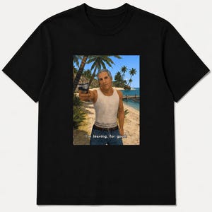 Może przedstawiać: Czarny t-shirt z krótkim rękawem z nadrukiem graficznym przedstawiającym mężczyznę w białym podkoszulku i niebieskich dżinsach, trzymającego pistolet na tropikalnej plaży. Tekst "I'm leaving, for good." jest nadrukowany na biało u dołu grafiki.