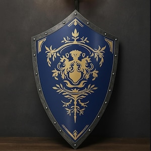 Op de afbeelding: Een marineblauw schild met een gouden embleem en rand. Het schild heeft een metalen rand met klinknagels. Het gouden embleem is een gedetailleerd bloemenontwerp. Het schild is een decoratief item met een middeleeuws thema.