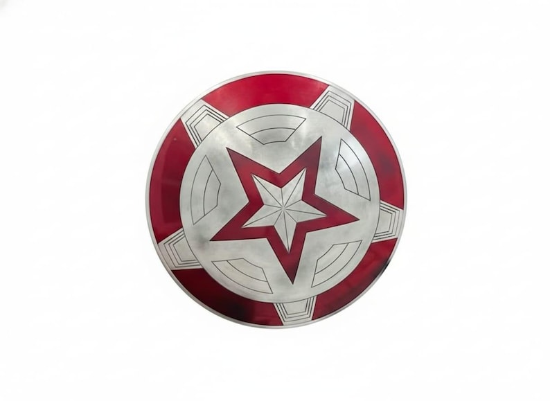 May include: A round shield with a red and silver design. The outer rim is red, and the center features a large red star within a silver circle. The shield has a metallic appearance.