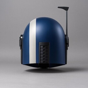 May include: A blue and white helmet with a vertical white stripe down the center. The helmet has black accents, including side details and a top antenna. The design is sleek and futuristic, suggesting a sci-fi or cosplay theme.