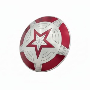 May include: A silver and red shield with a large white star in the center. The shield has a circular design with a red outer ring and a silver inner section. The star is outlined in red.