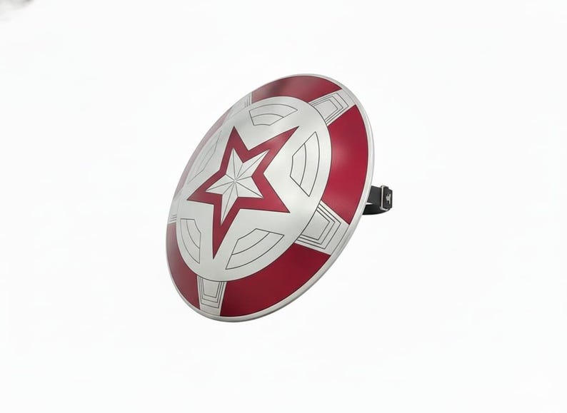 May include: A silver and red shield with a white star in the center. The shield has a circular shape with red and silver segments. A black strap is attached to the back of the shield.