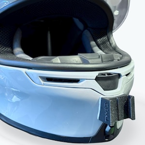 Peut inclure: Casque de moto bleu clair avec une visi&egrave;re transparente. L'int&eacute;rieur du casque est noir, et il y a un support noir &agrave; l'avant. La visi&egrave;re est ouverte, r&eacute;v&eacute;lant l'int&eacute;rieur. Le casque est con&ccedil;u pour la s&eacute;curit&eacute; et la protection.