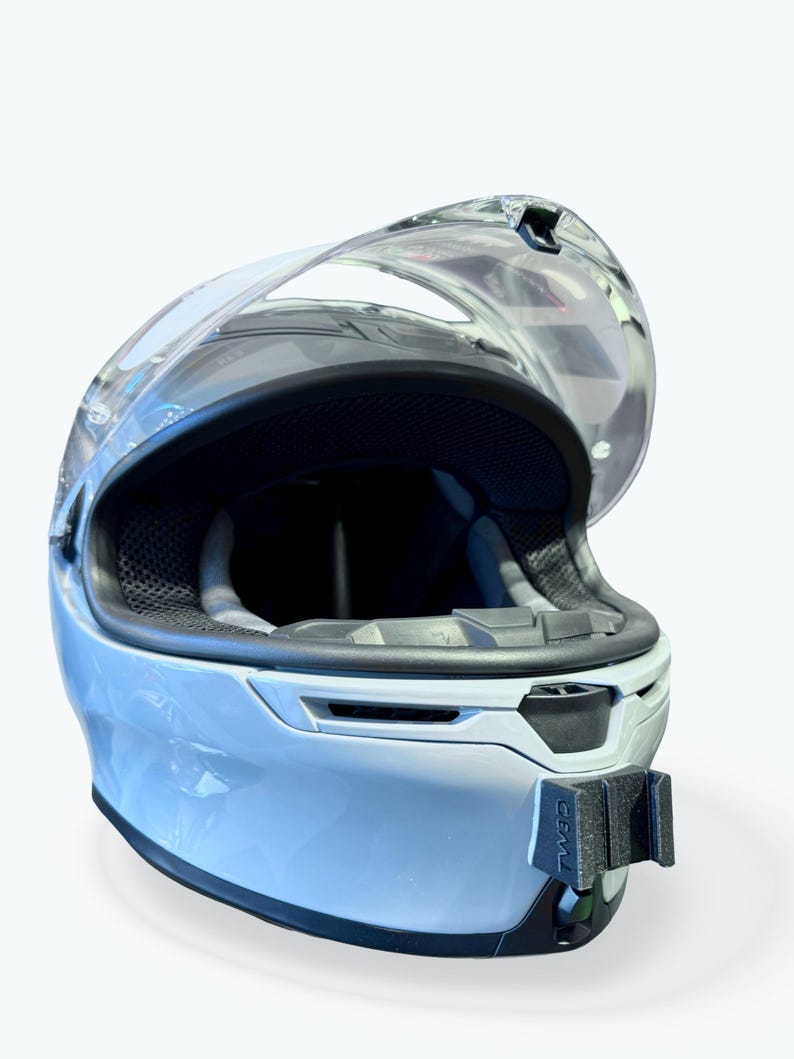 Peut inclure: Casque de moto bleu clair avec une visi&egrave;re transparente. L'int&eacute;rieur du casque est noir, et il y a un support noir &agrave; l'avant. La visi&egrave;re est ouverte, r&eacute;v&eacute;lant l'int&eacute;rieur. Le casque est con&ccedil;u pour la s&eacute;curit&eacute; et la protection.