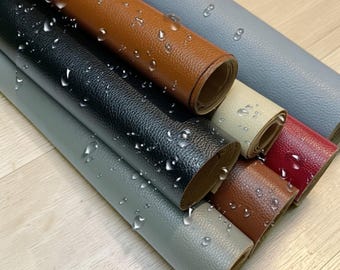 Puede incluir: Hojas enrolladas de cuero sintético en varios colores, incluyendo negro, marrón, gris y rojo. El material tiene una superficie texturizada y se muestra con gotas de agua, lo que sugiere una calidad impermeable. Los rollos están dispuestos diagonalmente, mostrando los diferentes colores.