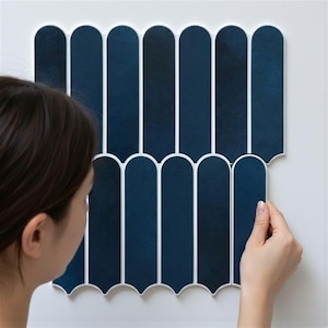 Puede incluir: Conjunto de baldosas decorativas azul marino con borde blanco, dispuestas verticalmente. Las baldosas tienen forma arqueada y se instalan en una pared blanca. Las baldosas miden unos 30 cm de largo.