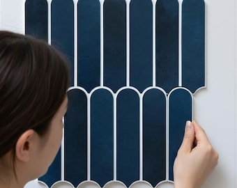 Puede incluir: Conjunto de baldosas decorativas azul marino con borde blanco, dispuestas verticalmente. Las baldosas tienen forma arqueada y se instalan en una pared blanca. Las baldosas miden unos 30 cm de largo.