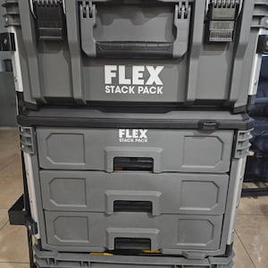 Puede incluir: Una pila de cajas de herramientas FLEX STACK PACK grises. La caja de herramientas superior tiene un asa y dos pestillos. Debajo hay dos cajones y un contenedor de almacenamiento inferior. El logotipo FLEX se muestra en cada sección.