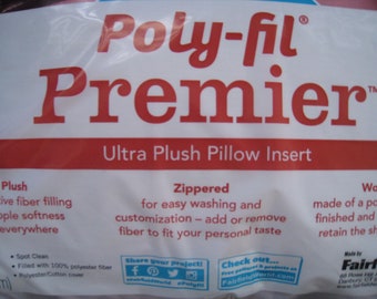 May include: A package for a Poly-fil Premier Ultra Plush Pillow Insert. The packaging is white with red text. The text includes "Ultra Plush Pillow Insert", "Zippered", and "Spot Clean". The pillow insert is filled with 100% polyester fiber and has a polyester/cotton cover.