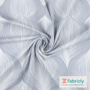 Könnte beinhalten: Nahaufnahme eines grauen Stoffes mit einem weißen, fließenden, blattartigen Muster. Der Stoff ist in einer Spirale zusammengefasst, die Textur und das Design zeigend. Das Fabricly-Logo befindet sich in der unteren rechten Ecke.