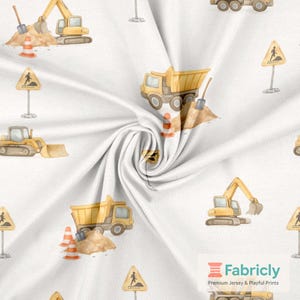May include: White fabric with a repeating pattern of yellow construction vehicles, including excavators, dump trucks, and bulldozers. The design also features orange traffic cones, sand piles, and pedestrian crossing signs. The Fabricly logo is in the bottom right corner.