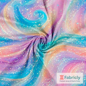 Può includere: Un tessuto vibrante con un design a spirale nei toni del blu, turchese, viola, rosa e arancione, cosparso di glitter. Il tessuto è piegato, creando un effetto strutturato. Il logo Fabricly è visibile in basso a destra.