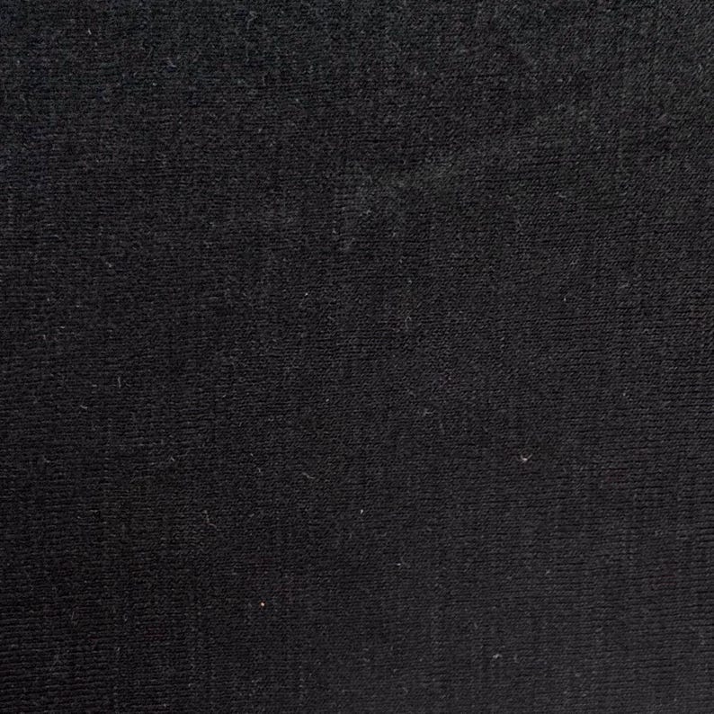 Black merino wool jersey fabric flat showing solid deep black knit texture