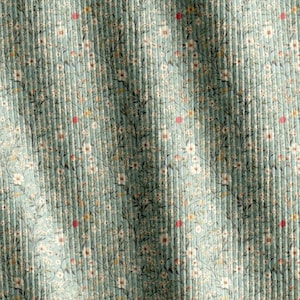Può includere: Primo piano di un tessuto con un motivo floreale. Il tessuto ha una trama a coste e uno sfondo verde acqua chiaro. Piccoli fiori bianchi, steli verde scuro e accenti rossi e gialli sono sparsi sul tessuto.