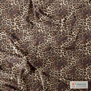 May include: Close-up of a leopard print fabric. The fabric displays a repeating pattern of dark brown spots on a tan and brown background. The fabric has slight wrinkles, creating shadows and depth.
