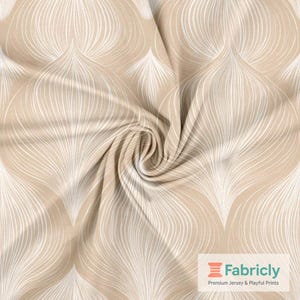 May include: Beige fabric with a white, flowing, leaf-like pattern. The fabric is gathered in a swirl, showing the texture and design. The Fabricly logo is visible in the bottom right corner.